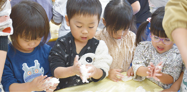 つきたての餅で鏡餅をつくる園児