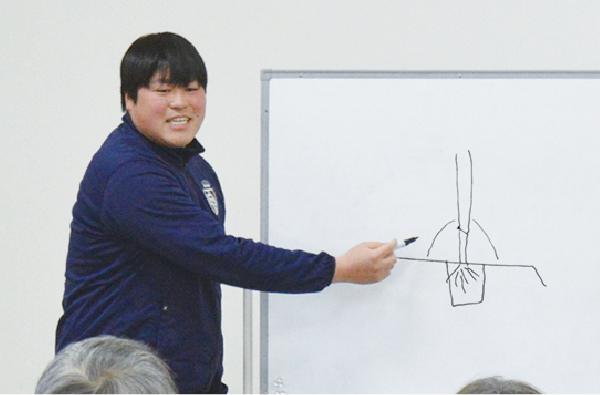 トマトの仕立て方を図解で説明する北部園芸センターの職員