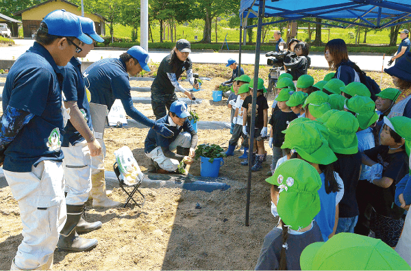 園児たちに作業の説明を行う参加者